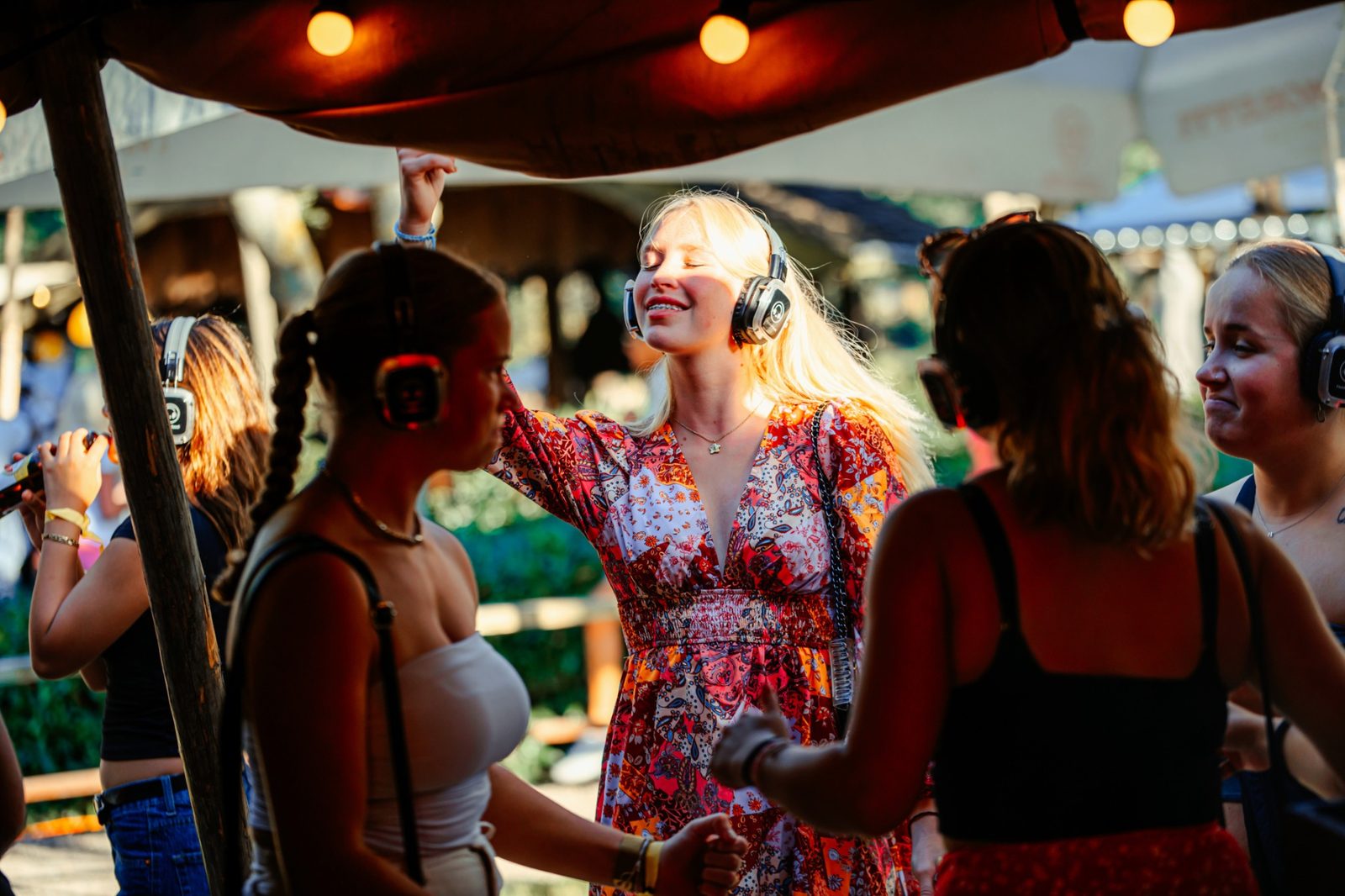 Silent disco atmosphere in the sun with dancing guests